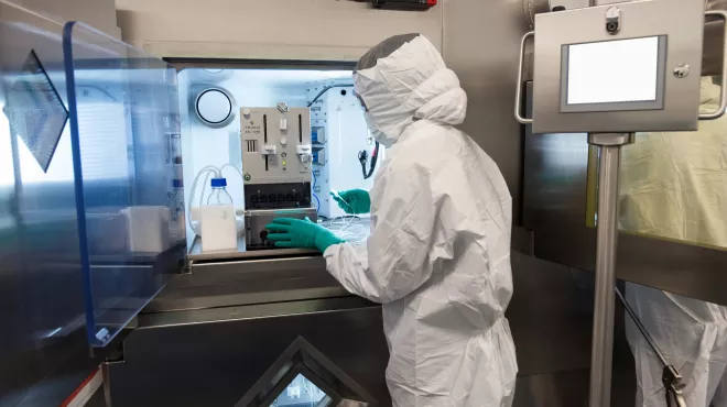Associate in full personal protective equipment using specialized equipment
