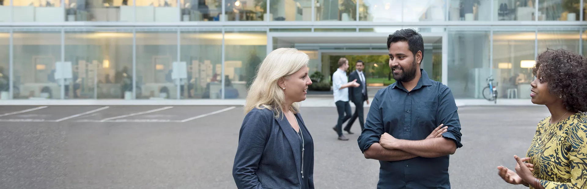 A group of Novartis associates engaged in conversation in front of the Novartis offices at Fabrikstrasse, Basel, Switzerland